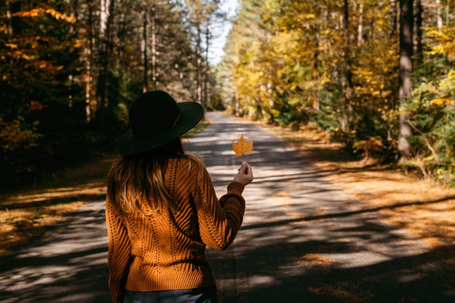 Фото Девушка в шляпе с кленовым листом в руке стоит на дороге, фотограф Gabriela Tulian