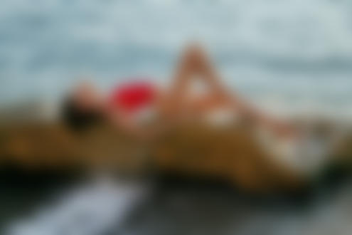 Фото Девушка в красном купальнике лежит на камне у воды, фотограф Irella Konof
