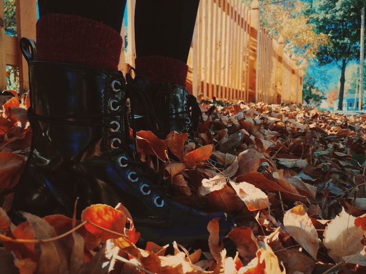 Фото Ножки девушки в ботинках, стоящей в осенней листве