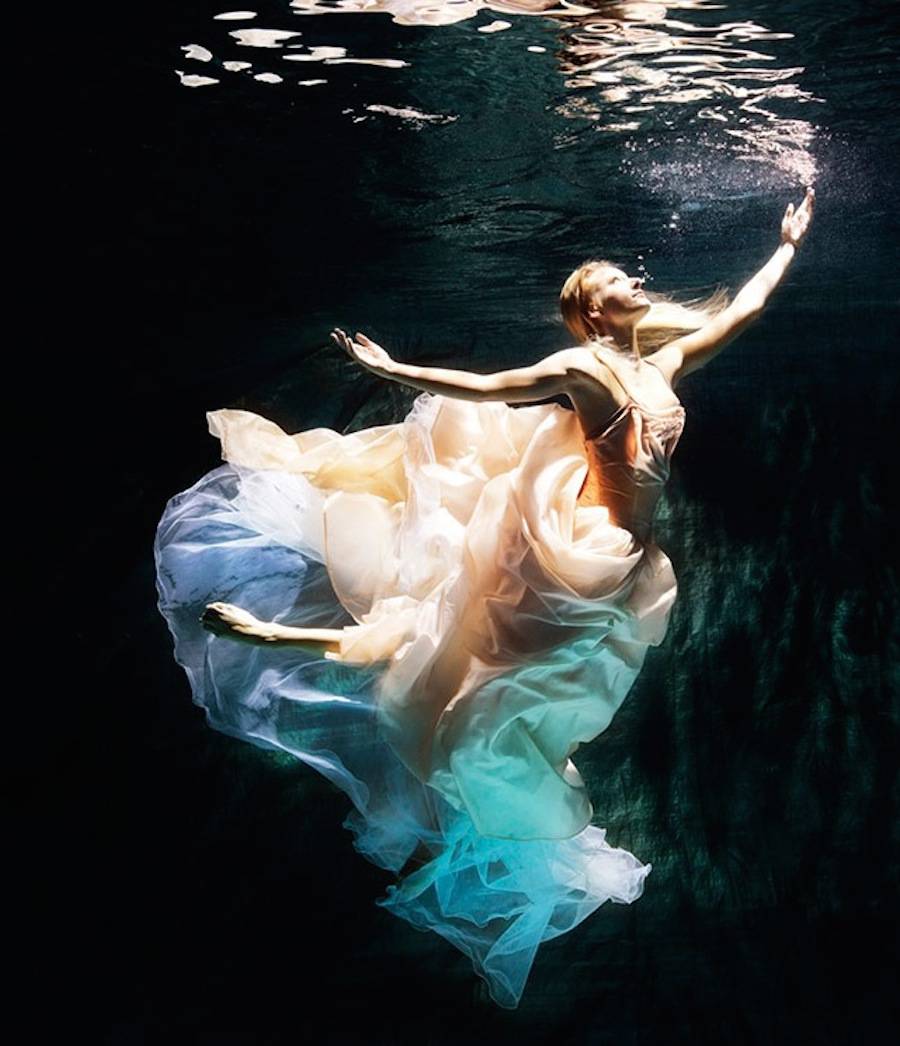 Фото Красивая девушка блондинка в пышном платье распахнув руки плывет к  поверхности воды, by Henrik Sorensen