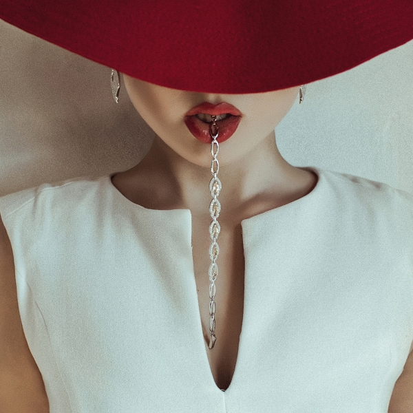 Фото Девушка в красной шляпе и цепочкой во рту, фотограф Дан Хечо