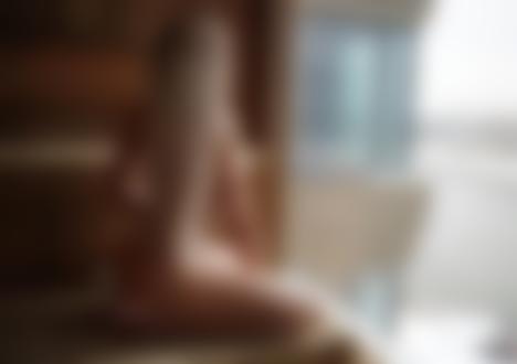 Фото Девушка блондинка в нижнем белье спиной сидит у окна