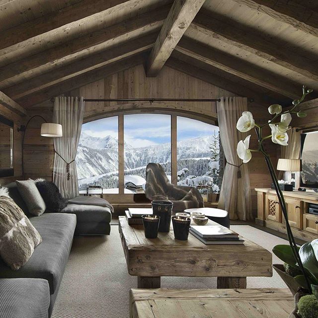 Фото Комната в деревянной доме, вид из окна которой открывается на  заснеженные горы