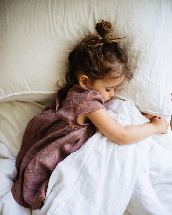 Фото Девочка в платье спит, обняв ручками одеяло