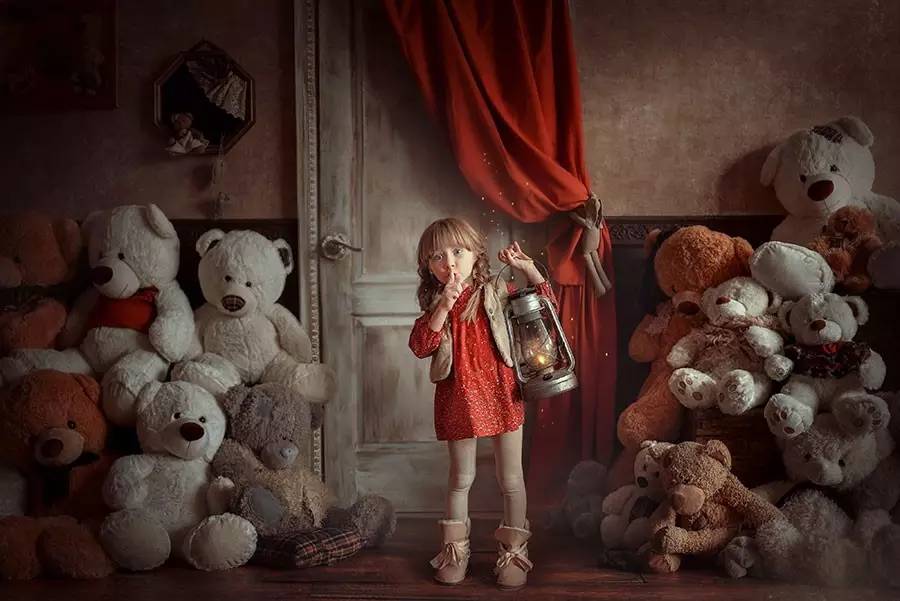 Фото Девочка с фонарем в руке стоит посреди игрушечных медведей, фотограф Анна Гис