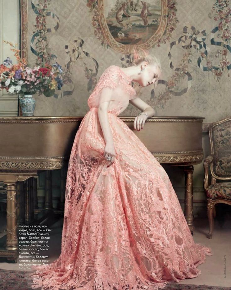 Фото Девушка в нежно розовом ажурном длинном платье в грусти облокотилась на рояль