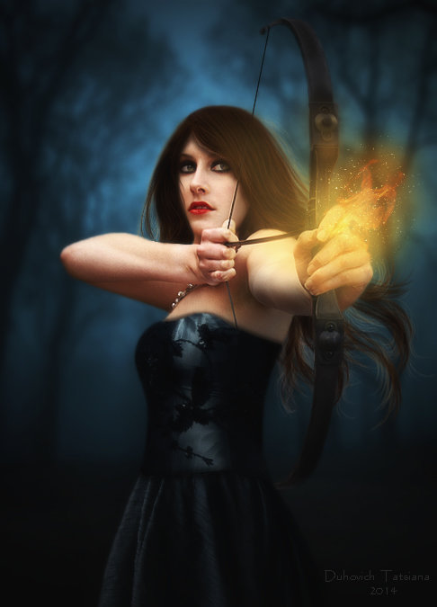 Фото Девушка - лучница, с огненной стрелой, на размытом фоне леса, фотограф Татьяна Духович
