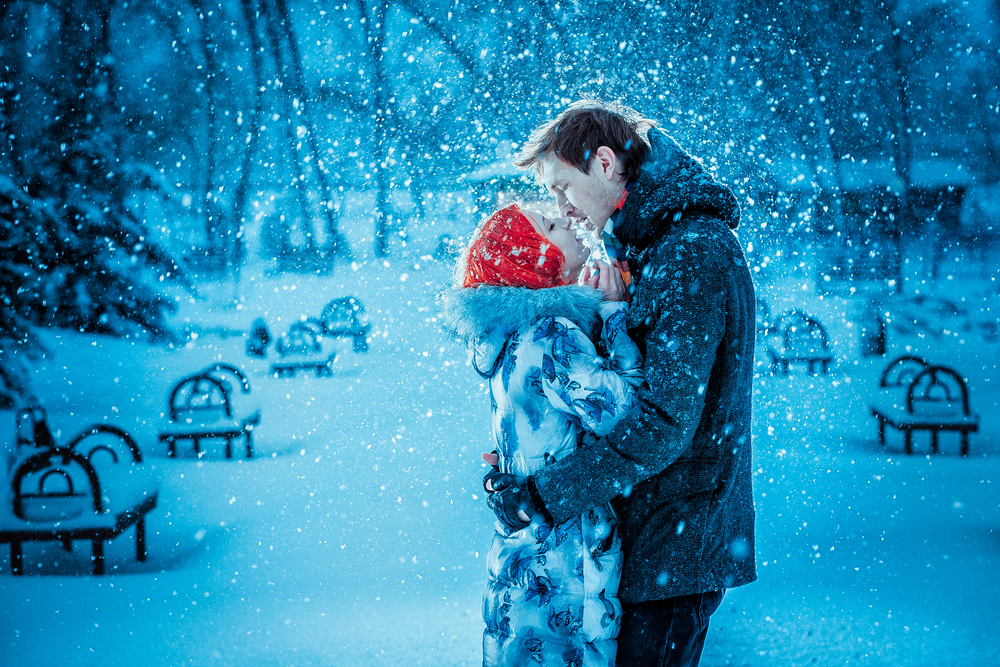 Фото Влюбленная пара на фоне зимнего пейзажа под падающим снегом