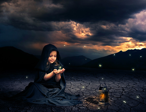 Фото На потрескавшейся земле сидит улыбающаяся девочка, над ее руками парит светящийся мотылек, рядом стоит фонарь, на фоне горного пейзажа