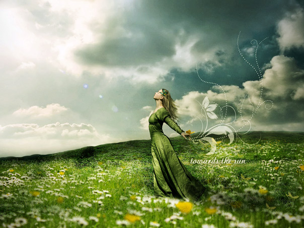 Фото Девушка в длинном зеленом платье стоит в траве с цветами на фоне неба и облаков (Towards the sun / Навстречу солнцу)