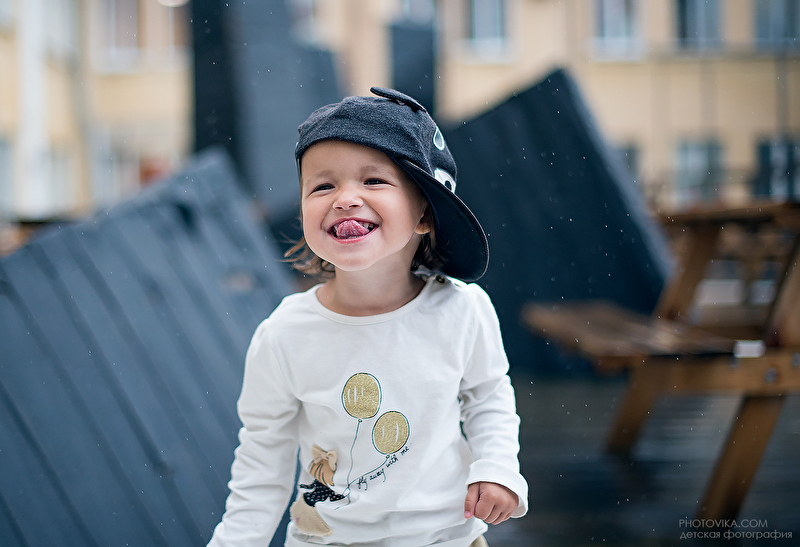 Фото Улыбающийся мальчик с высунутым языком в кепке на крыше дома, фотограф Виктория Старцева