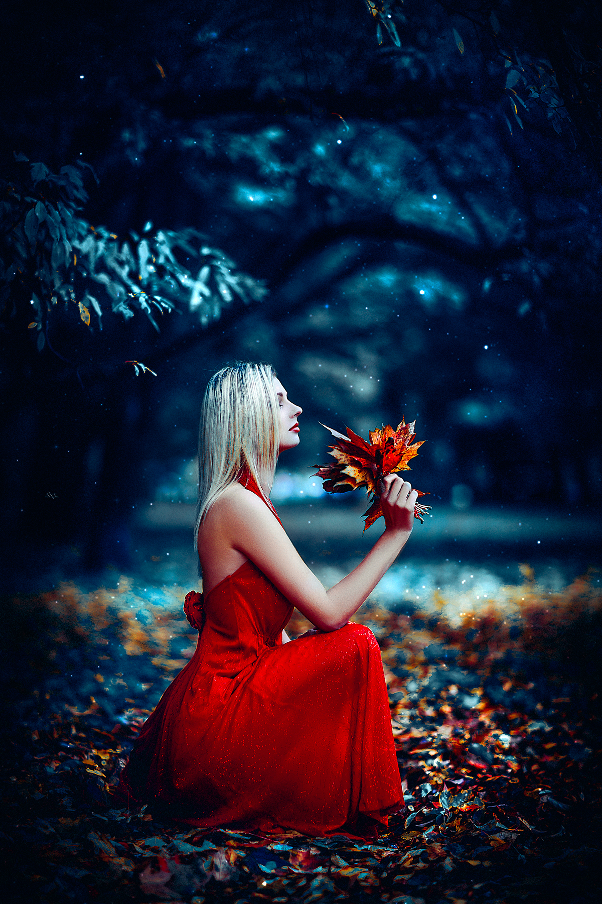 Фото Белокурая девушка в красном платье с осенними листьями в руках на размытом фоне природы. Фотограф Руслан Болгов