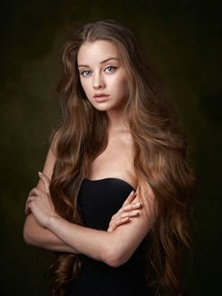 Фото Модель Maria Dreamgirl с длинными волосами, в черном платье сидит