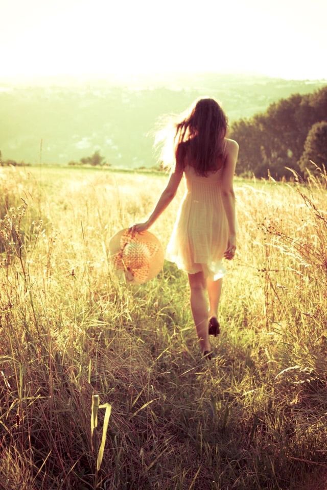 Фото Девушка со шляпой в руке идет по траве