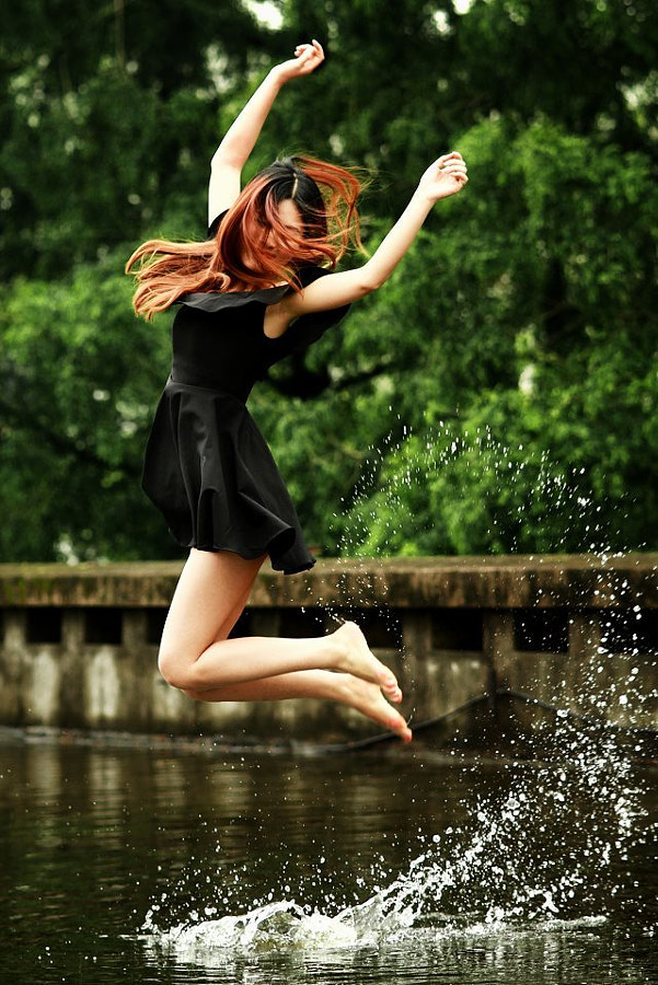 Фото Девушка в черном платье в прыжке над водой, фотограф T T