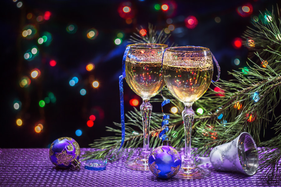 Два бокала с шампанским, новогодние игрушки, елочная ветка на столе, на фоне боке, фотограф Igor Sarapulov