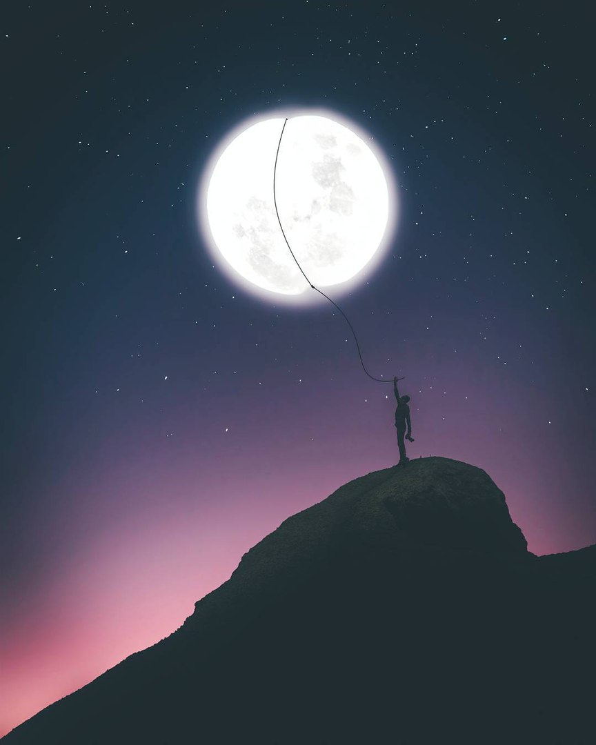Фото Мужчина, стоящий на вершине горы, держит луну как воздушный шарик