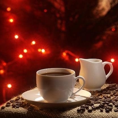 Фото Чашка кофе стоит на кофейных зернах