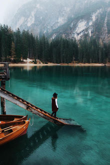 Фото Девушка спускается по ступеньками, к которым привязаны две лодки, к озеру, которое окружено лесом и горами (© StepUp), добавлено: 24.01.2018 14:01