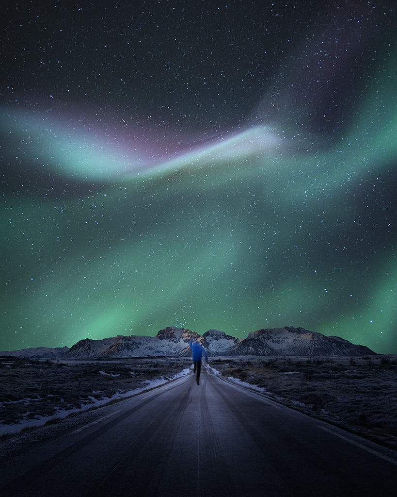 Фото Парень на дороге перед небом с северным сиянием, фотограф Jay Daley