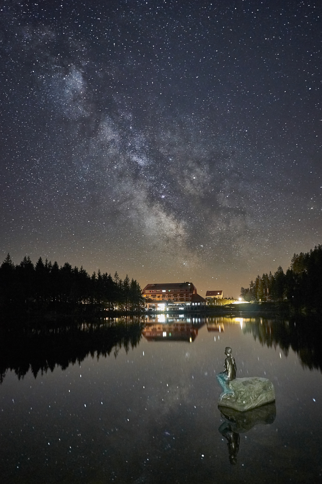 Фото В воде стоит памятник Русалочки под облачным звездным небом, фотограф Benjamin Sum