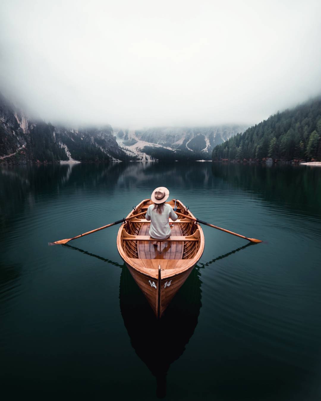 Фото Девушка в шляпе сидит в лодке посреди озера, by Marcel Siebert