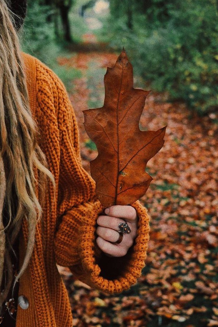 Фото Девушка держит в руке осенний дубовый листок