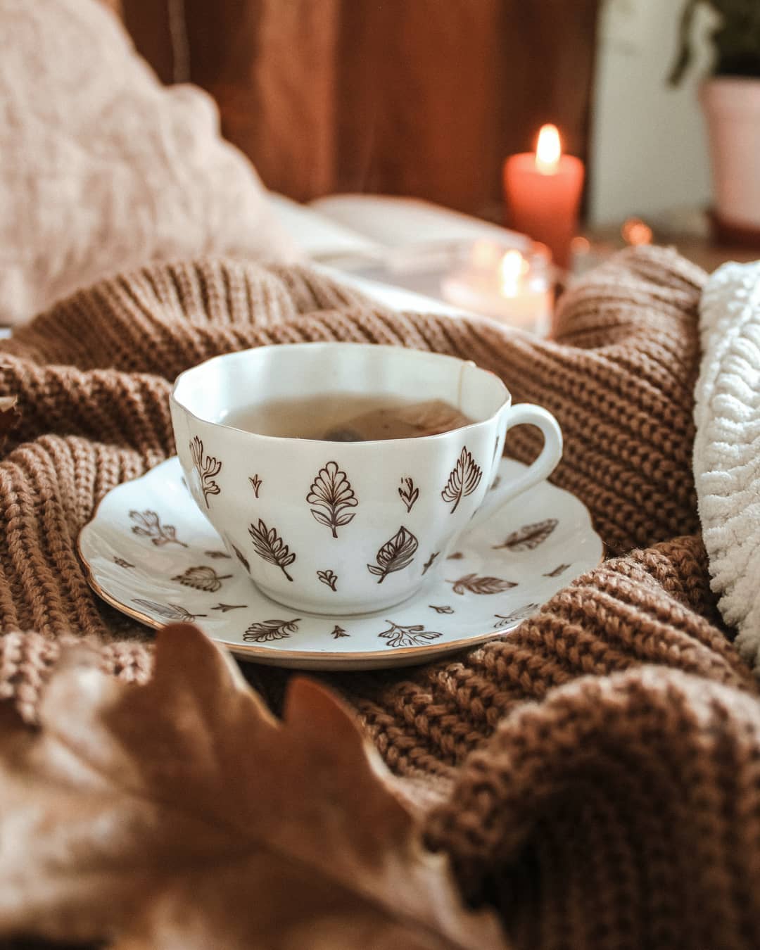 Фото Чашка кофе на вязаной вещи, горящая свеча и осенний листок, by annasofiaparkby
