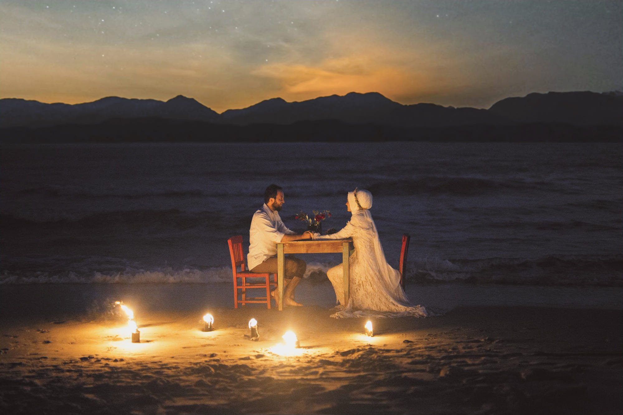 Фото Свадебная пара сидит за столиком на фоне моря. Фотограф Durdali Dalgin