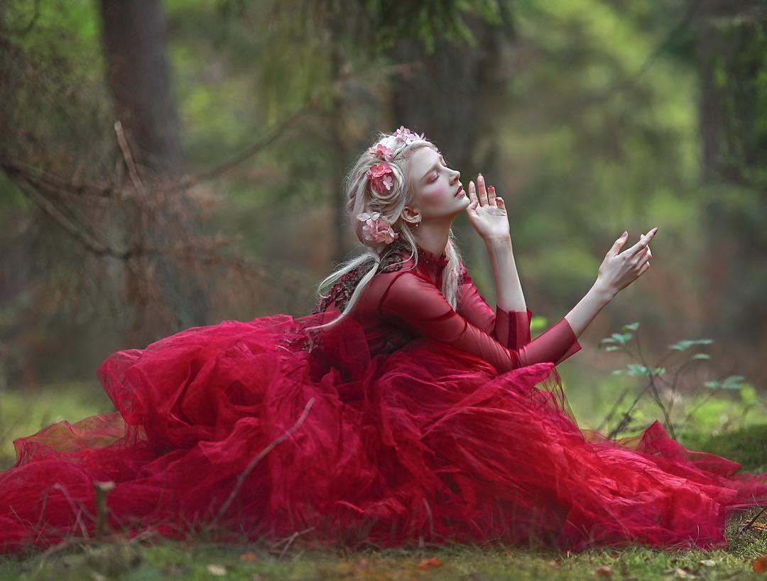  Красивая девушка в красном платье сидит на земле, by Agnieszka Lorek