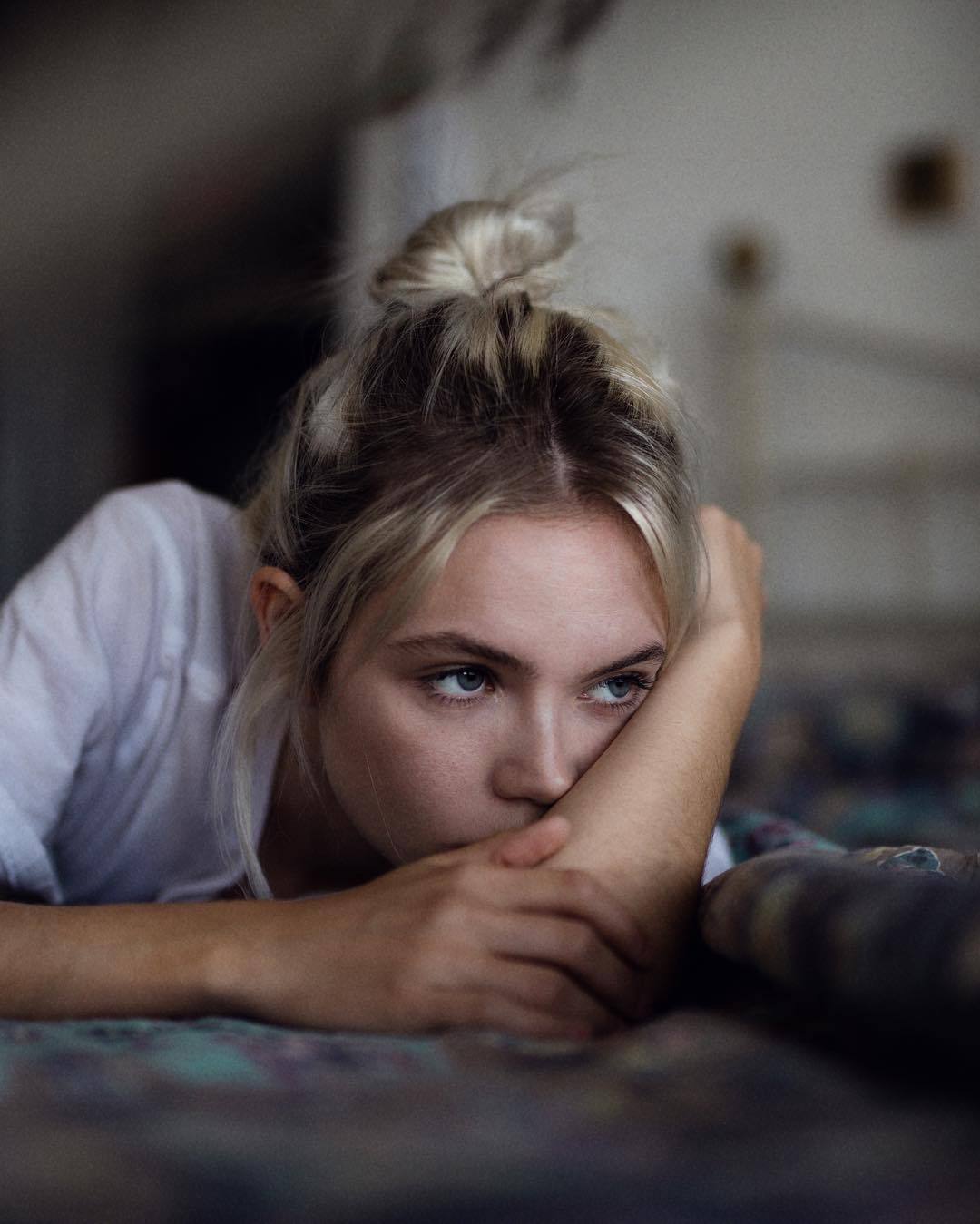 Фото Задумчивая девушка лежит на постели