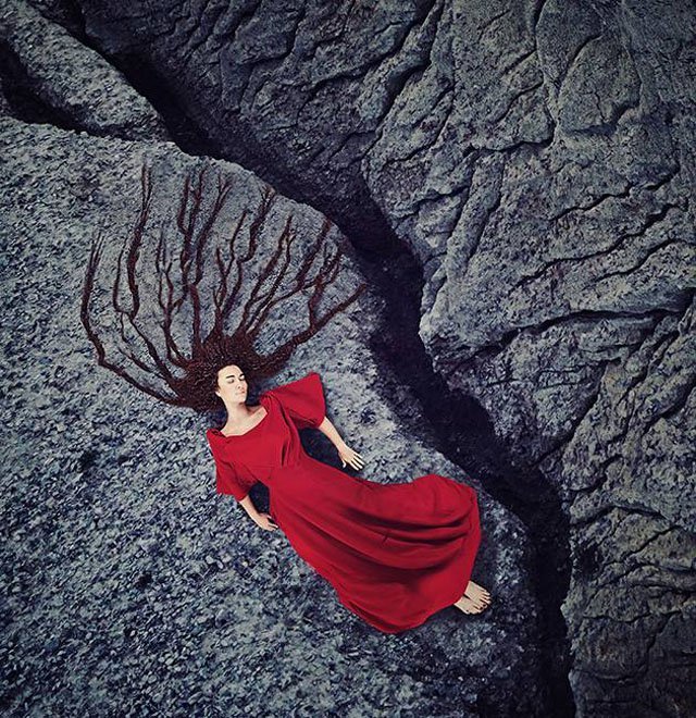 Фото Девушка в красном платье, с длинными волосами лежит на земле. Фотограф художник Килли Спэрри / Kylli Sparre
