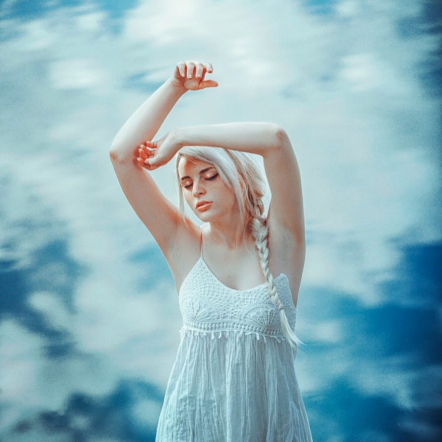 Фото Девушка с поднятыми руками стоит на фоне облачного неба, фотограф Rafa Sаnchez