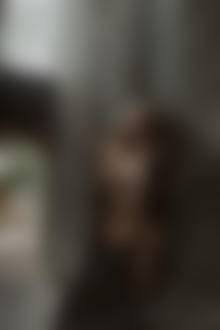 Фото Девушка с обнаженной грудью, с сигаретой в руке, стоит у стены. Фотограф Мочульский Леонид