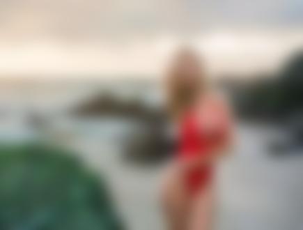 Фото Модель Тиффани Тотт в красном купальнике стоит на фоне природы