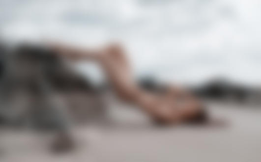 Фото Обнаженная девушка лежит на песке, положив ножки на камень. Фотограф Виктор Макарчук