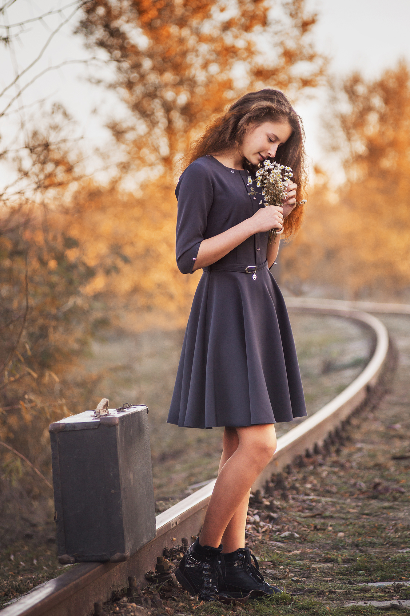 Фото Девушка с цветами в руках стоит на железной дороге рядом с чемоданом, фотограф Неволов Илья