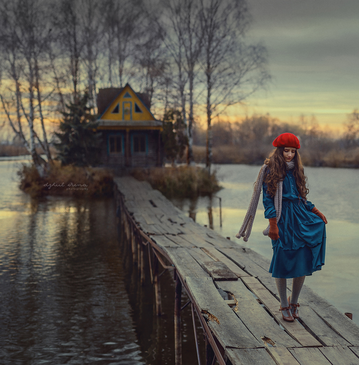 Фото Девушка в синем платье и красном берете стоит на мосту, ведущему к дому в окружении воды. Фотограф Ирина Джуль