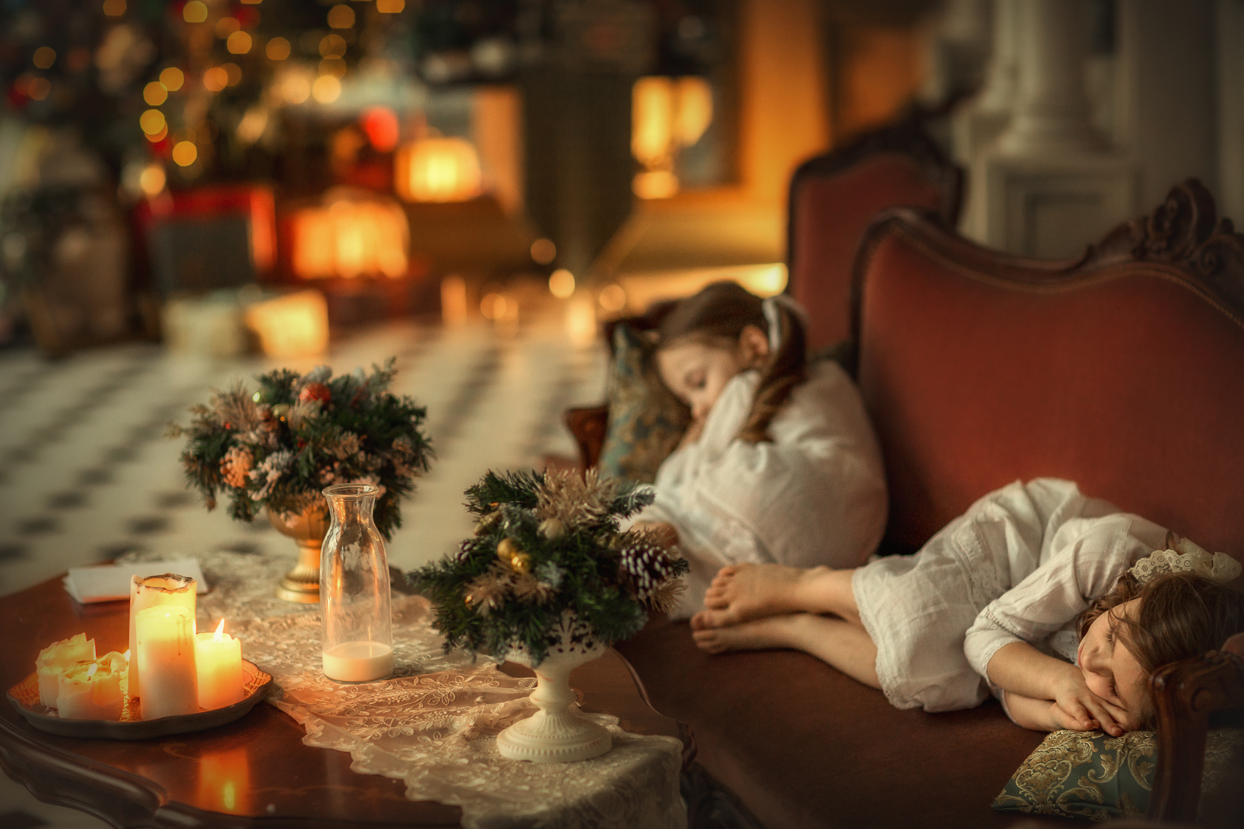 Фото Девочки спят на диване перед столом в комнате с елкой. Фотограф Савченко Кристина