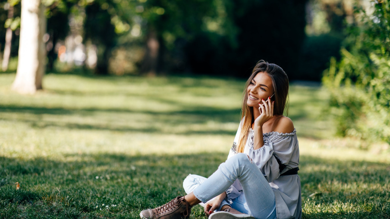Фото Девушка сидит на траве с телефоном в руке, by Milenko Dilas