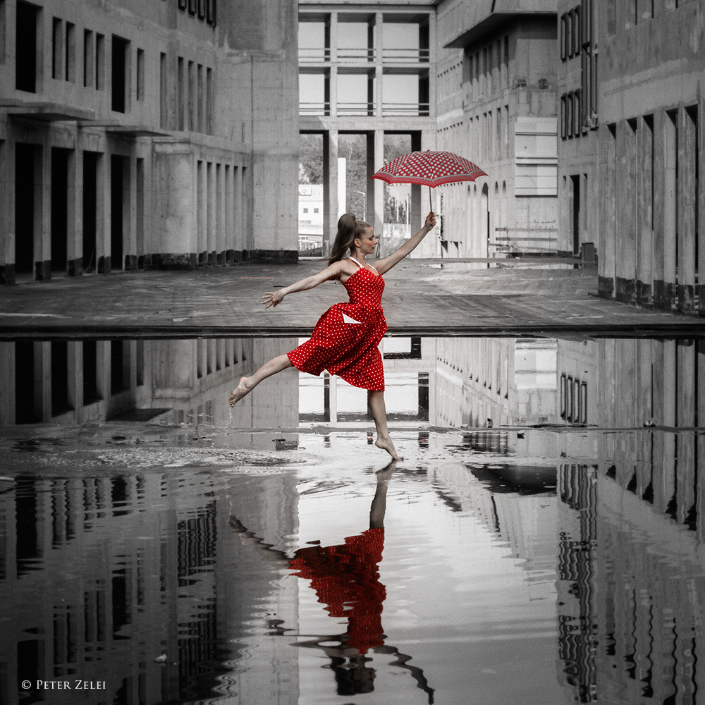 Фото Девушка в красном платье, с зонтом в руке, стоит в луже, фотограф Peter Zelei
