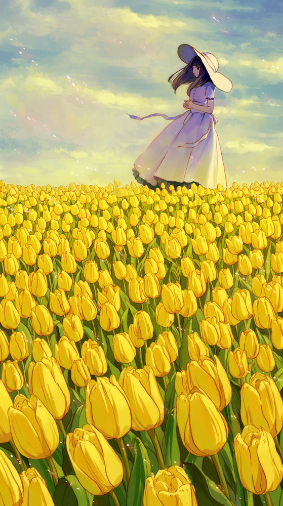 Фото Девушка в шляпе стоит на поле желтых тюльпанов