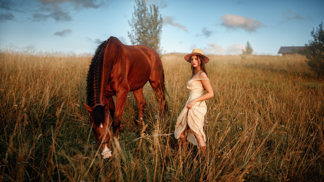Фото Модель Анна Воронцова в шляпе стоит рядом с лошадью на поле, фотограф Georgy Chernyadyev