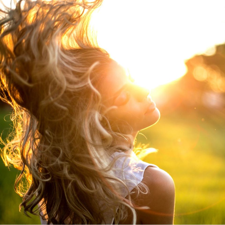Фото Девушка - блондинка с развевающимися волосами в лучах солнца