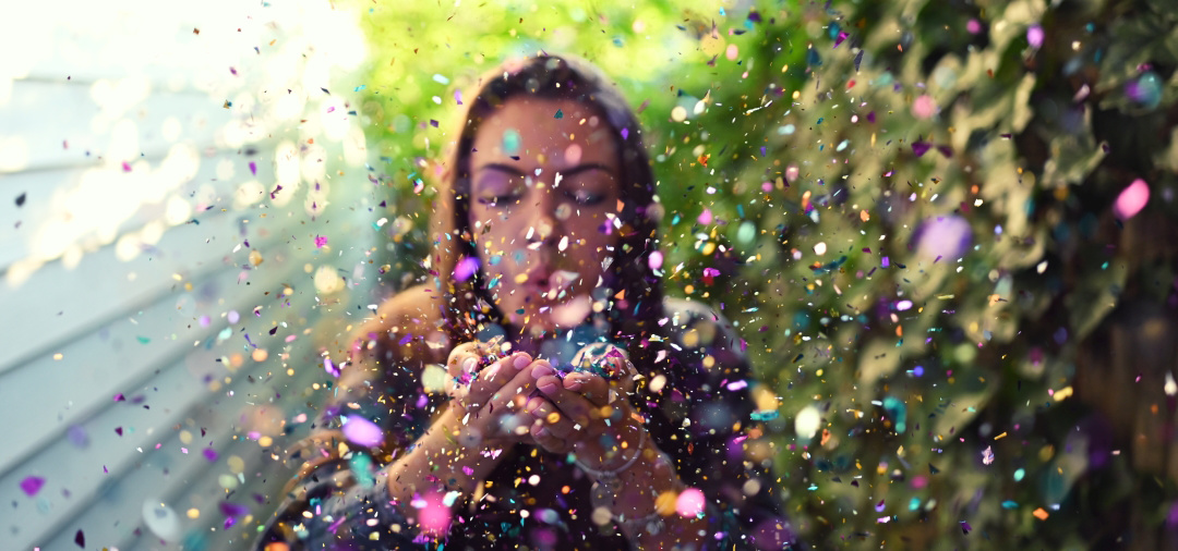 Фото Девушка сдувает с рук разноцветную пыльцу
