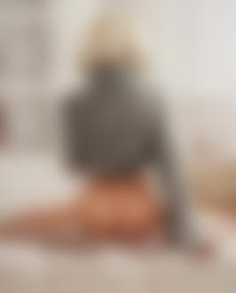 Фото Модель Екатерина Ширяева в приподнятом свитере сидит на диване с оголенной попкой