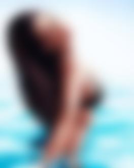 Фото Длинноволосая девушка в черном купальнике стоит по пояс в воде, by ivantalavera