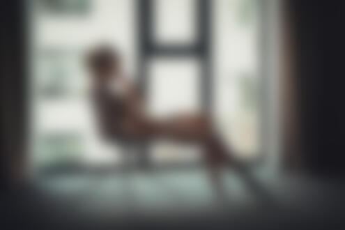 Фото Обнаженная девушка с тату на теле сидит на стуле посреди комнаты на фоне окна, фотограф Alex Heitz
