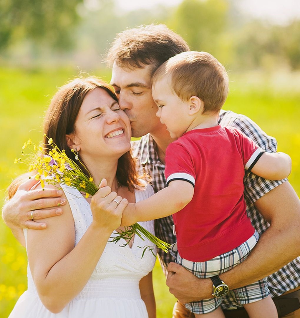 Фото Супруг целует свою супругу и держит на руке ребенка