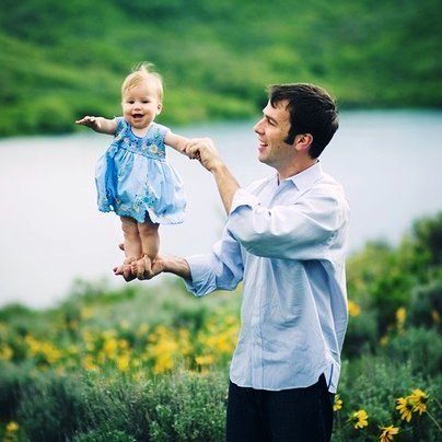 Фото Папа держит на руках маленькую дочку